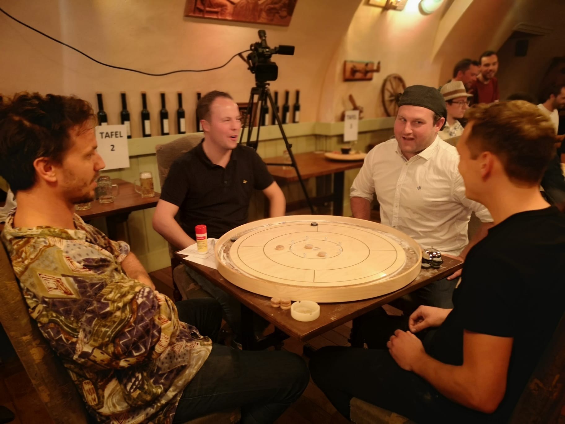 Spelers rond een crokinole bord